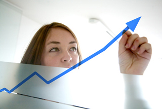 Business woman draws an arrow on a graph